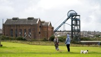 Warga menikmati suasana di depan museum pertambangan Haig Colliery Mining Museum di Whitehaven, Inggris (4/10). Sebuah proposal diajukan untuk menggali ulang tambang batu bara, tidak jauh dari museum batu bara tersebut. Rencananya, batu bara akan diproses di tempat ini, 550 km sebelah barat laut Ibu Kota London.