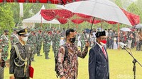 Prosesi pemakaman tampak digelar di tengah hujan. Menko Polhukam Mahfud MD tampak hadir dalam prosesi pemakaman Sudi Silalahi.