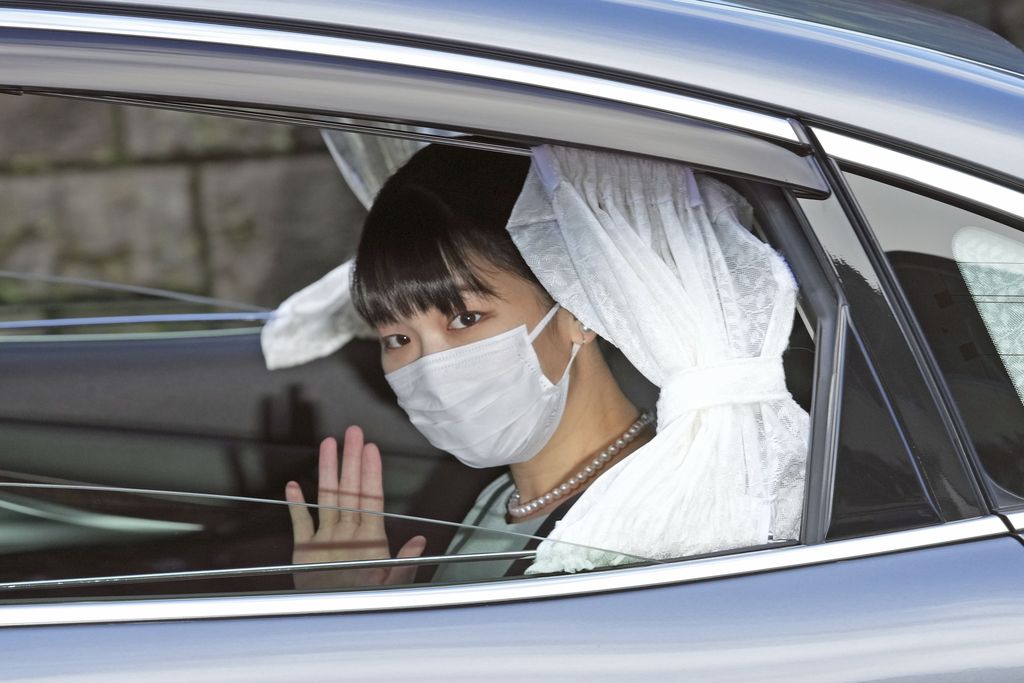 Japan's Princess Mako waves from a car as she leaves her home in Akasaka Estate in Tokyo Tuesday, Oct. 26, 2021. Mako and her commoner boyfriend Kei Komuro tied the knot Tuesday without wedding celebration in a marriage that has split the public opinion over her would-be mother-in-law's financial controversy. (Chika Oshima/Kyodo News via AP)