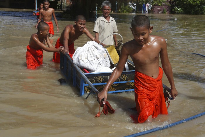 Saat Para Biksu Menembus Banjir di Kamboja Para biksu mengevakuasi barang-barang melintasi banjir yang merendam pagoda, di luar kota Phon Penh, Kamboja, (26/10/2021). Luapan sungai menyebabkan tempat ibadah mereka di Wat Kampong Kdol terendam banjir.