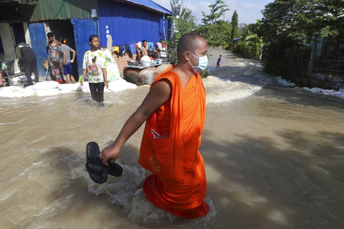 Saat Para Biksu Menembus Banjir di Kamboja Para biksu mengevakuasi barang-barang melintasi banjir yang merendam pagoda, di luar kota Phon Penh, Kamboja, (26/10/2021). Luapan sungai menyebabkan tempat ibadah mereka di Wat Kampong Kdol terendam banjir.