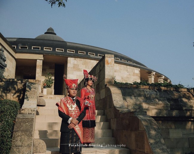 Pasangan ini mengadakan sesi foto prewedding di Amanjiwo, Yogyakarta. Lokasi ini menjadi tempat favorit selebriti Tanah Air melakukan sesi foto. Dalam foto ini terlihat pasangan calon pengantin memakai busana adat yang menambah kesan elegan. Foto: Instagram @fatahillahginting.