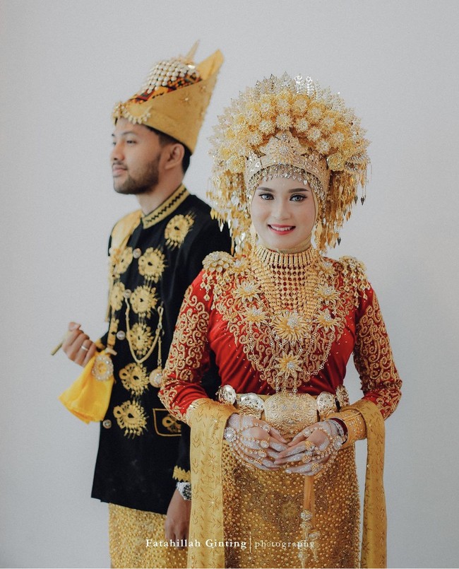 Kamu bingung menentukan lokasi foto prewedding? Foto dengan konsep indoor atau di dalam ruangan dengan latar belakang putih seperti pasangan calon pengantin yang memakai busana adat ini bisa menjadi inspirasi. Foto: Instagram @fatahillahginting.
