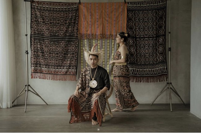 Lagi kain khas Sumatera Utara menjadi inspirasi prewedding satu. Dekorasi kain ulos membuat foto terlihat estetik. Foto: Instagram @katakitaphoto.