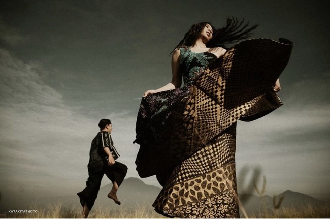 Konsep foto prewedding tanpa bersentuhan lainnya, kamu bisa ikuti pasangan ini. Foto dengan konsep outdoor dan mengenakan kain khas daerah yang memesona. Ditambah dengan gaya candid menambah kesan estetik. Foto: Instagram @katakitaphoto.