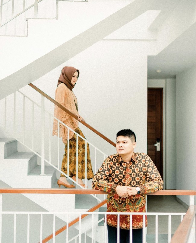 Kain batik juga bisa menjadi pilihan bagi kamu yang ingin mengadakan sesi foto prewedding. Pose wanita seolah sedang turun dari anak tangga. Dan pria seolah menunggu kedatangan wanita.  Foto: Instagram @merakitales.id.