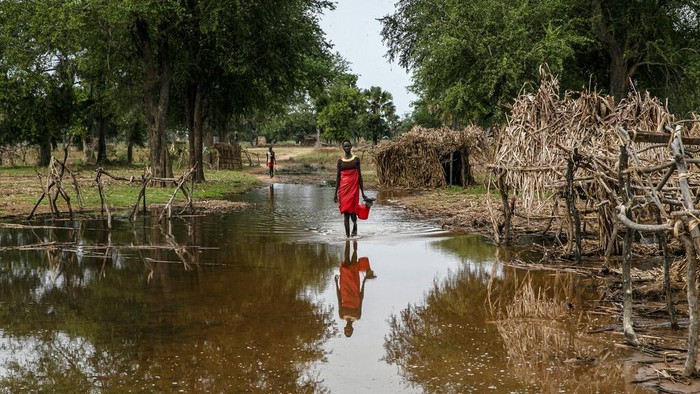 Children standing on a small mud dyke are reflected in the stagnant water, in Langic, Northern Bahr el Ghazal State, South Sudan, Wednesday, Oct. 20, 2021. This is the third straight year of extreme flooding in South Sudan, further imperiling livelihoods in the worlds youngest country. A five-year civil war, hunger and corruption have all challenged the nation. Now climate change, which the United Nations has blamed on the flooding, is impossible to ignore.(AP Photo/Adrienne Surprenant)