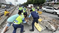 Sejumlah petugas dari Dinas Perhubungan DKI Jakarta, melakukan evakuasi separator busway yang hancur berserakan akibat ditabrak truk muatan tanah, di Jalan MT Haryono, Cawang, Jakarta Timur, Rabu (27/10/2021).
