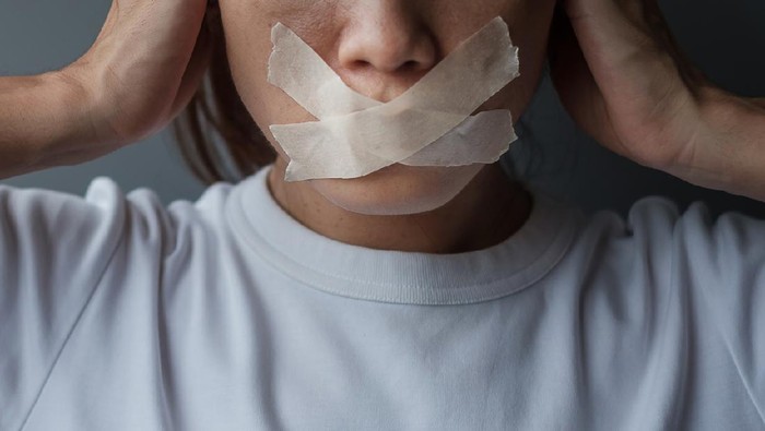 plester tidur woman with mouth sealed in adhesive tape. Free of speech, freedom of press, Human rights, Protest dictatorship, democracy, liberty, equality and fraternity concepts