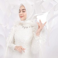 Ria Ricis tampil cantik dan memukau dengan pakaian serba putih. Pada bagian leher dress yang dikenakan oleh Ricis tampak dihiasi dengan kristal tempel yang membuat penampilannya semakin elegan. Untuk hijab, Ria memilih model segiempat yang simpel. Foto: Instagram/@fdphotography