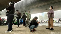 Para pemotor berteduh di kolong jembatan di Jakarta (25/10). Sesuai peringatan BMKG, fenomena La Nina yang artinya yang artinya anak perempuan berisiko memicu bencana hidrometeorologi. Bencana ini meliputi banjir, longsor, angin kencang atau puting beliung ataupun terjadinya badai tropis. (Rengga Sencaya/detikcom)