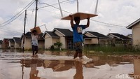 Warga membawa perabot melintasi banjir di Pekanbaru, Riau, (25/10). BMKG menyarankan masyarakat dan pemerintah segera mengambil langkah yang diperlukan menghadapi La Nina. Langkah ini untuk menekan efek yang dialami masyarakat menghadapi siklus bencana tahunan. (Raja Adil/detikcom)