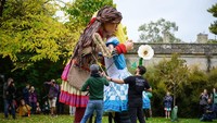 Ini potret Little Amal memeluk Alice dari kisah Alice in Wonderland di Botanic Gardens pada 26 Oktober 2021 di Oxford, Inggris yang bikin haru masyarakat Inggris. Foto: Getty Images/Leon Neal