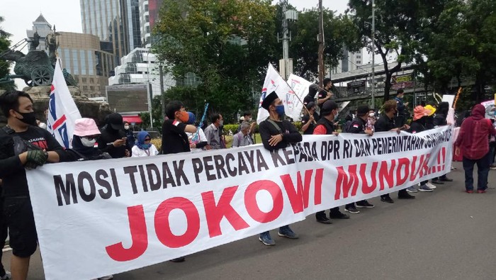 Demonstran bentangkan spanduk Jokowi Mundur.