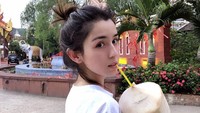 Tanpa riasan wajah sema sekali, seperti ini kecantikan Hanikezi yang alami. Ia sedang menikmati segarnya air kelapa.