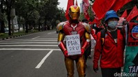 Ada pula demonstran yang mengenakan kostum pahlawan super Iron Man sembari membawa poster bertuliskan Korban PHK DRU Daya Radar Utama.
