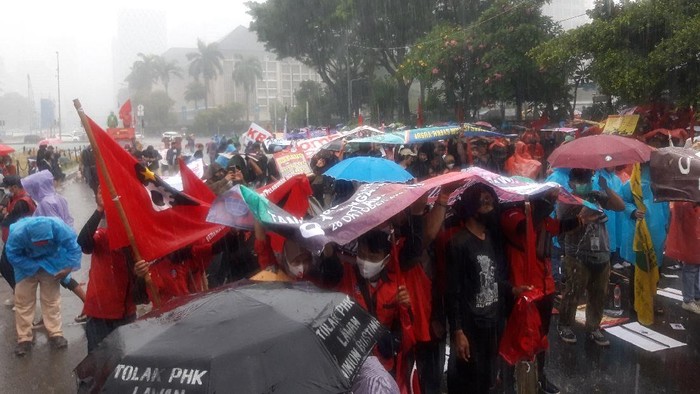 Hujan mengguyur lokasi demonstrasi di Patung Kuda Arjuna Wiwaha, Jl Medan Merdeka Barat, Jakarta.