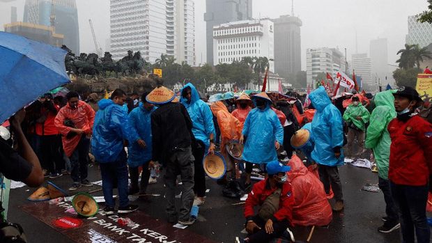 Hujan mengguyur lokasi demonstrasi di Patung Kuda Arjuna Wiwaha, Jl Medan Merdeka Barat, Jakarta.