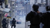 Massa mundur ke pemukiman saat polisi menembakkan gas air mata (27/10). Pendemo menolak kenaikan harga bahan bakar di tengah sulitnya ekonomi saat pandemo COVID-19.