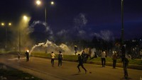 Pengunjukrasa bertahan dari gas air mata hingga malam saat unjukrasa menolak kenaikan harga bahan bakar di Saquisili, Selasa (26/10).