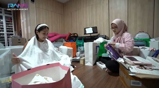 Selain itu Nagita Slavina juga telah menyiapkan kain yang nantinya akan digunakan untuk mengangkat bayi sehabis mandi. Nagita pun mencoba langsung menggunakannya. Foto: YouTube/Rans Entertainment