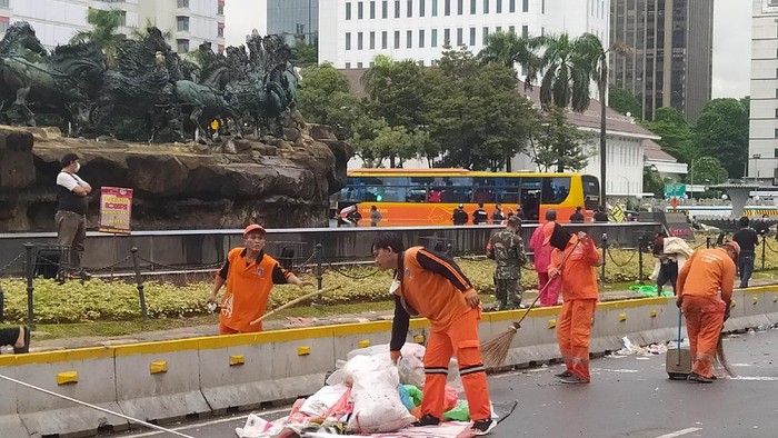 Pendemo Jokowi sudah mulai bubar. Petugas PPSU bersihkan lokasi demo di Jl Medan Merdeka Barat.