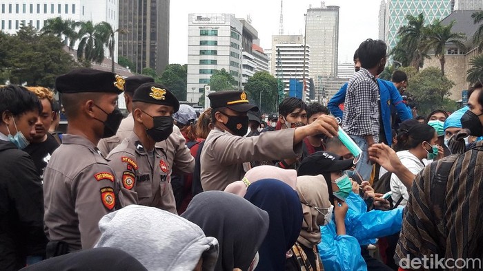 Polisi bagi-bagi masker kepada pendemo di Patung Kuda Jakpus