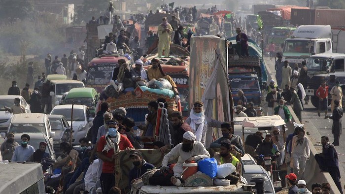 Supporters of Tehreek-e-Labiak Pakistan, a radical Islamist party, help their colleague, left, who was injured in clashes with police, during their protest march toward Islamabad, on a highway in the town of Sadhuke, in eastern Pakistan, Wednesday, Oct. 27, 2021. Violence at the anti-France Islamist rally in Sadhuke left at least one police officer and two demonstrators dead. ​They demanded the expulsion of France's envoy to Pakistan over publication of caricatures of Islam's Prophet Muhammad in France. (AP Photo/K.M. Chaudary)