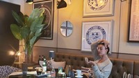 Dalam sebuah acara, Georgina tampak cantik dengan balutan gaun yang sopan. Ia juga tampak merapikan hiasan wajahnya dan menikmati secangkir kopi. Foto: Instagram @cristiano @georginagio
