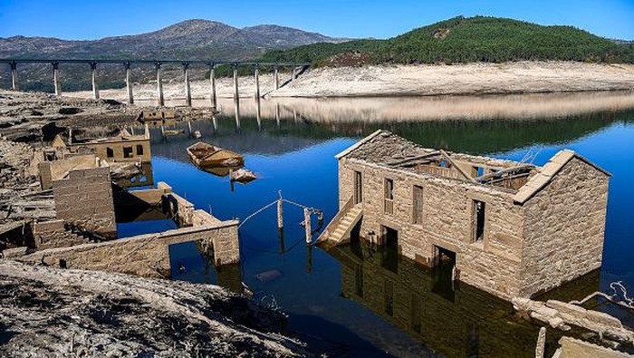 OURENSE, SPAIN - OCTOBER 27: A view of the partly submerged Aceredo village buildings as they emerge from the river Lima on October 27, 2021 in Lobios, Ourense, Spain.  The town of Aceredo has resurfaced during a low state of flow in the dam which was built 29 years ago and turned the valley into a reservoir. Some 250 people were forced to move to a village above the Lindoso reservoir and a church was moved to another town stone by stone, when the Portuguese state-owned EDP electricity company ran the Lindoso reservoir hydroelectric plant. (Photo by Octavio Passos/Getty Images)
