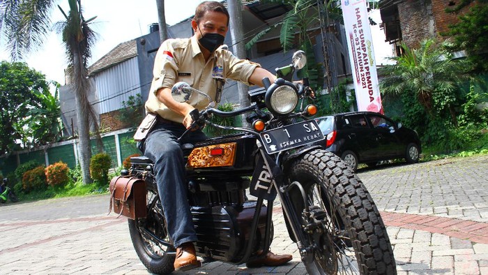 INOVASI SEPEDA MOTOR LISTRIK DENGAN BATERAI KOMPUTER JINJING BEKAS Kepala Sekolah Cone Kustarto (kanan) menunjukkan cara kerja purwarupa sepeda motor listrik hasil inovasinya di SMKN 5 Malang, Jawa Timur, Jumat (29/10/2021). Sepeda motor listrik tesebut dirakit dengan memanfaatkan baterai komputer jinjing bekas dan mampu melaju dengan kecepatan 70 kilometer per jam dengan lama pengisian ulang hanya selama 2 jam saja. ANTARA FOTO/Ari Bowo Sucipto/hp.