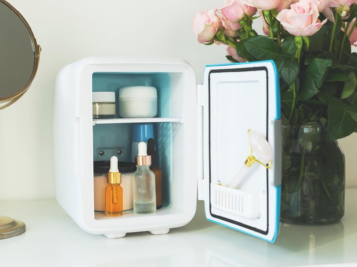 Mini fridge on the vanity table. Selfcare concept. Keep skincare, makeup and beauty product cool and fresh. Extend shelf live of creams, serums. Keep your beauty products organized and cool.