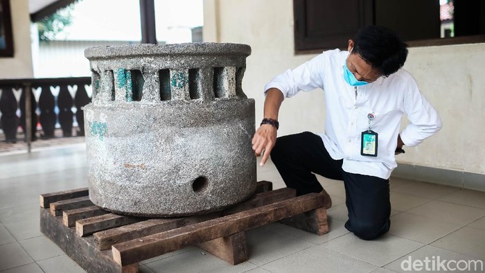 Petugas melihat dari dekat batu dari abad ke 17 yang sudah di pindahkan ke Balai Budaya Condet, Jakarta, Jumat (29/10/2021).