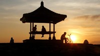 Orang-orang menyaksikan matahari terbit di Pantai Sanur di Denpasar, Bali, Kamis (28/10/2021). Bali kembali membuka pintu untuk wisatawan asing. AP Photo/Firdia Lisnawati