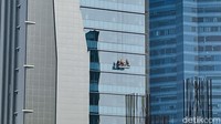 Di musim hujan, pekerja pembersih kaca atau yang dikenal Gondola Man harus ekstra kerja membersihkan kaca-kaca gedung pencakar langit.