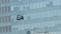 Rela bertaruh nyawa, para pekerja membersihkan kaca gedung pencakar langit yang menjulang tinggi di Ibukota Jakarta, Jumat (29/10/2021).