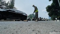 Petugas Satpol PP DKI Jakarta melakukan operasi sapu bersih ranjau paku.