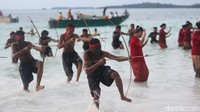 Sandiaga didampingi oleh Bupati Malra M Thaher Hanubun yang juga tidak mengenakan alas kaki menuju tempat acara sambil diarak dengan tarian tradisional dan bentangan bendera merah putih yang dipegang oleh anak-anak Kei.   