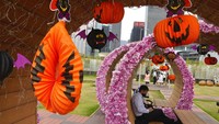 Seorang pengunjung beristirahat di dekat beberapa dekorasi Halloween di sebuah taman di Hong Kong.