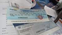 Ada dua cek di dalam dompet tersebut. Salah satu cek sudah dalam kondisi terparaf namun belum tertera nilainya. (dok Istimewa)