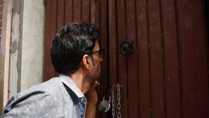 Seorang pria berusaha mengintip rumah keluarga Chundawats (BBC)