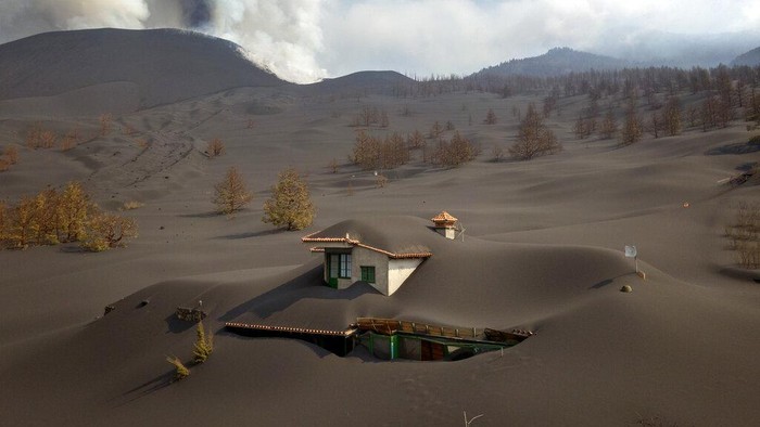 A house is covered by ash from a volcano as it continues to erupt on the Canary island of La Palma, Spain, Saturday, Oct. 30, 2021. An erupting volcano in the Spanish island of La Palma continued to emit vast amounts of magma, gases and ash on Saturday, after days of intense seismic activity and more than five weeks since it erupted. (AP Photo/Emilio Morenatti)