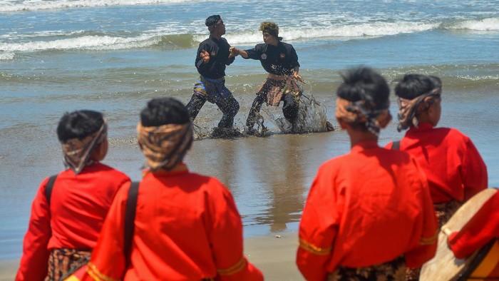 FESTIVAL SILEK ON THE SEA Peserta menampilkan atraksi silek saat Festival Silek on the Sea, di Pantai Kata, Pariaman, Sumatera Barat, Minggu (31/10/2021). Festival silat di tepi laut tersebut diikuti perguruan silat tradisi di Sumbar dalam rangka melestarikan budaya dan promosi wisata pantai kota Pariaman. ANTARA FOTO/Iggoy el Fitra/hp.