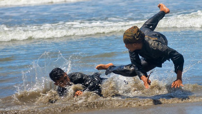 Peserta menampilkan atraksi silek saat Festival Silek on the Sea, di Pantai Kata, Pariaman, Sumatera Barat, Minggu (31/10/2021). Festival silat di tepi laut tersebut diikuti perguruan silat tradisi di Sumbar dalam rangka melestarikan budaya dan promosi wisata pantai kota Pariaman. ANTARA FOTO/Iggoy el Fitra/hp.