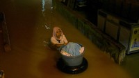 Warga menyelamatkan sejumlah pakaian miliknya dari banjir di kawasan Kampung Aur, Medan Maimun, Kota Medan, Sumatera Utara, Minggu (31/10/2021) pagi.