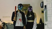 Ranty Maria bareng Rayn Wijaya juga tampil kompak menggunakan pakaian bernuansa hitam dan putih dengan corak seperti berlumuran darah. Tapi, semua gagal fokus dengan penampakan kepala hantu yang muncul di balik pintu. Foto: dok. Instagram Ranty Maria