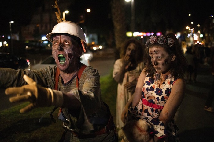 A girl wears zombie make-up and outfit as she participates in the Zombie Walk 2021, part of Halloween weekend in Tel Aviv, Israel, Saturday, Oct. 30, 2021. (AP Photo/Ariel Schalit)