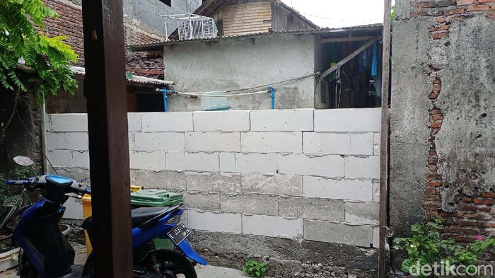 Kebingungan tampak pada raut wajah Muhammad Ridwan. Akses ke rumah warga Rungkut Menanggal nomor 32, RT 05, RW 01, Surabaya ini ditembok oleh tetangganya.