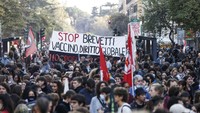 Massa berjalan kaki di Roma pada Sabtu (30/10) ketika KTT G20 yang mempertemukan para pemimpin dunia digelar.