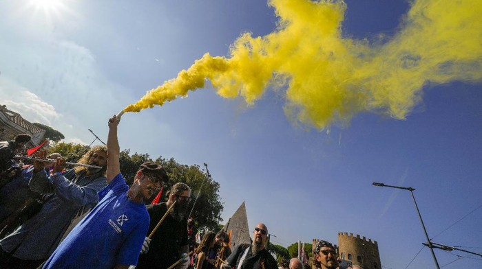 Demonstrators light flares during a march in Rome, Saturday, Oct. 30, 2021, the day a Group of 20 summit started in the Italian capital. Factory workers, climate activists, antiglobalization campaigners, unions, feminist groups, vaccine skeptics and political extremists are seizing the opportunity to voice anger while world's leaders are gathering in town for the first time in presence since the COVID-19 pandemic started in 2019. (AP Photo/Luca Bruno)